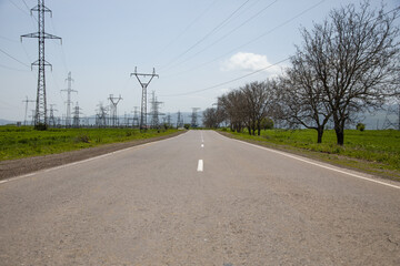 Electricity tower and empty asphalt road