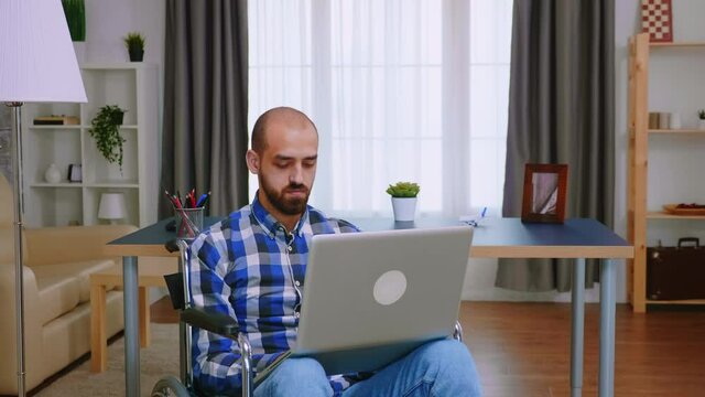 Corporatist in wheelchair working on laptop from home office. Handicapped invalid paralysed freelancer, immobilized entrepreneur working from home, ilness and disability