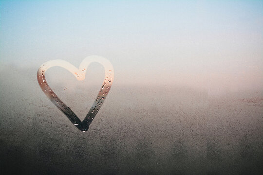 Draw a heart on the mirror with water drops. The inscription on the sweaty glass - love and heart