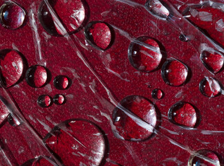 Texture. Silhouettes of flowing raindrops are located on the red leather background. Abstract fantasy.