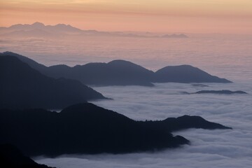 landscape view of sunrise over the mountains with fog & clouds