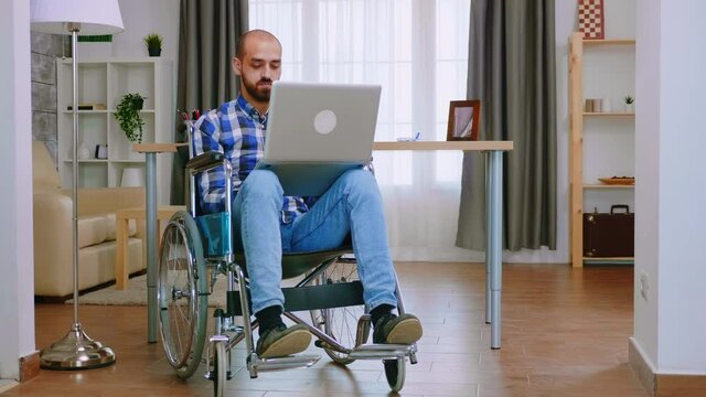 Manager in wheelchair working on laptop from home office. Handicapped invalid paralysed freelancer, immobilized entrepreneur working from home, ilness and disability