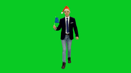 Young handsome man in santa hat walking with waving flag of EU against green screen background