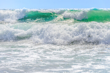 sea waves with white breakers running ashore, bright sunny day, beautiful natural landscape