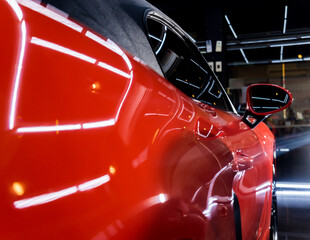 Car service worker applying nano coating on a car detail