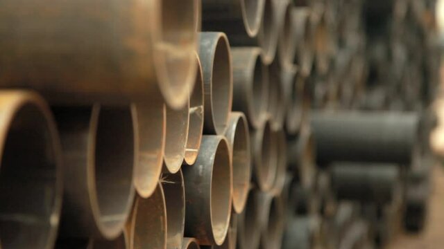 Large pile of steel pipes used for wells with water.Frame shot from the slider.Water well drilling.Close-up.