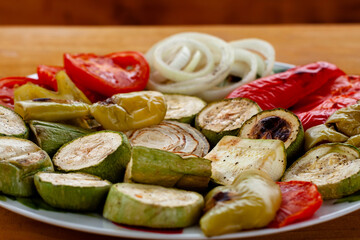grilled vegetables on a plate. tomatoes with a tender crust. zucchini, onion, pepper