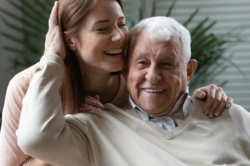 Close up headshot loving elderly father stroking overjoyed daughter head, family enjoying tender...