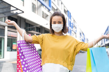 Asian women live a new normal life during the outbreak of COVID-19 . Asian women wear masks or face shield and holding shopping bags happily. Live a normal life during the epidemic.