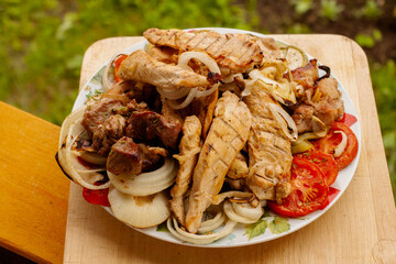 grilled meat and vegetables on a plate. chicken, meat, pepper, onion, tomatoes