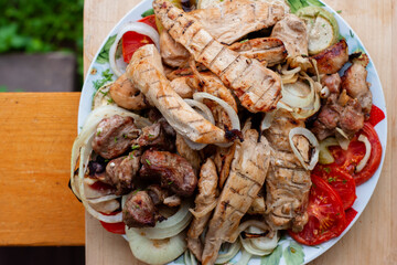 grilled meat and vegetables on a plate. chicken, meat, pepper, onion, tomatoes