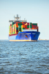 Large cargo container ship sailing from Europoort (Rotterdam, Netherlands) in an open sea on a clear day, close-up. Freight transportation, global communications, logistics, environmental damage theme © Alex Stemmer
