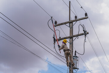 The power lineman use clamp stick (insulated tool) to closing a transformer on energized...