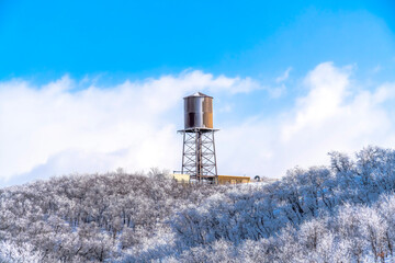 Water tank storage container on a tower at the snowy slope of Wasatch Mountains