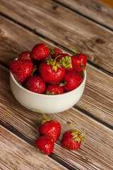 strawberries in a bowl on wooden table