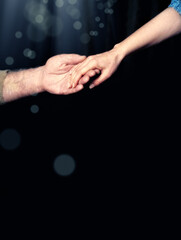Fototapeta na wymiar close up senior adult male hand and young adult female hand holding each other