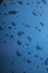 Fototapeta na wymiar Raindrops on a blue car close-up.