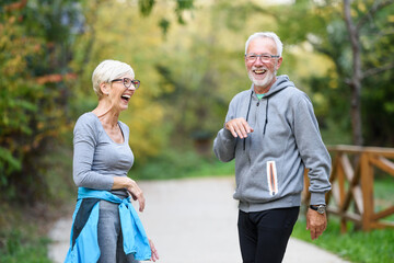 Active senior couple exercising in the park having fun laughing