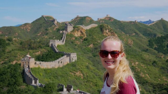 Young blond woman in Chinese great wall smiling