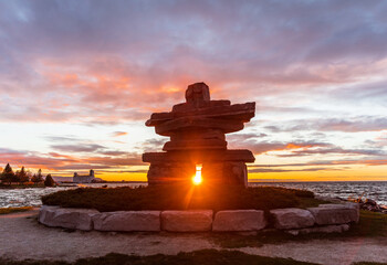 Sunset framed behind Inukshuk in Collingwood waterfront park - Powered by Adobe