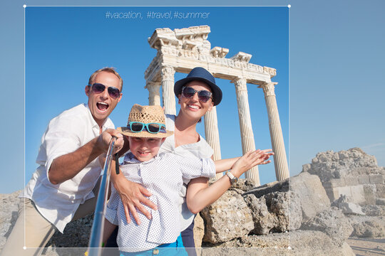 Happy family making a selfie photo using a samrtphone and Selfie stick on summer vacation in Turkey, Side, Manavgat with Temple of Apollo ruines on background. Family traveling concept image.