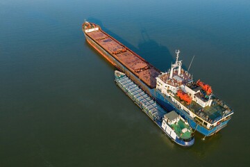 Commercial ship crossing the river. Aerial view. 