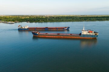 Commercial ship crossing the river. Aerial view. 