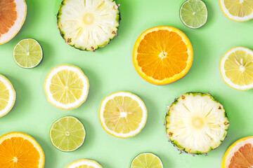 Collection of fresh lime, lemon, orange, citrus, grapefruit, pineapple slice on green background.