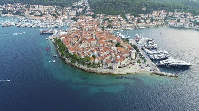 Aerial view of Korcula,  Croatia with mediterranean architecture, marina, port and luxury yachts and sailboats embarked. Warm, sunny summer day in Dalmatian city. Vacations in Croatia.