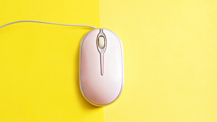 pink computer mouse on a bright yellow background