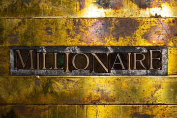 Millionaire text formed with real authentic typeset letters on vintage textured silver grunge copper and gold background