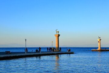 Entering the port of Mandraki in the historic Rhodes. There are two bronze deer sculptures in the columns.