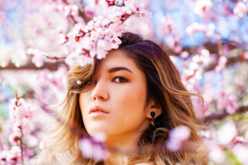 Portrait of a young blonde girl posing in spring park