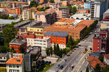Fototapeta na wymiar Green energy. Solar panels on the roof of a red building in the historical center of Brescia, Lombardy, Italy. Italian modern architecture. Sustainable development of society. Electricity. Eco.