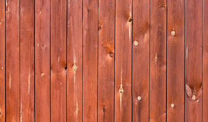 Fototapeta premium The texture of a tree painted red. Background of vertical wooden boards in red color. Template for the designer, banner