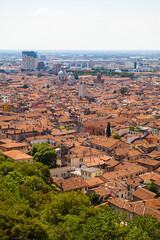 Fototapeta premium Aerial view of the historical center of Brescia (Lombardy, Italy) with tiled red roofs, chimneys, cathedral's domes and tall white brick old towers. Traditional European medieval architecture. 