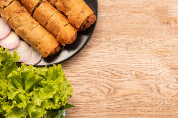 fried spring rolls and vegetables on wood