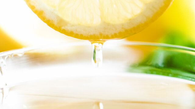 Macro image of honey droplet falling from cut lemon slice