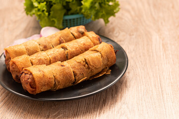 fried spring rolls and vegetables on wood
