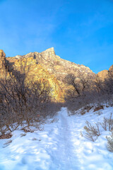 Trail on a snowy mountain overlooking a steep rocky peak in Provo Canyon Utah