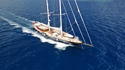 Fototapeta premium Aerial drone photo of beautiful sail boat with wooden deck sailing the Aegean deep blue sea, Greece