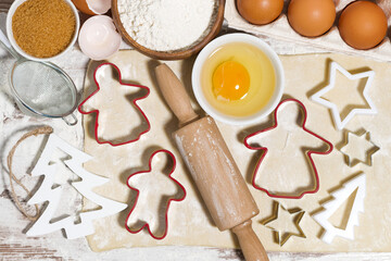 Ingredients for baking Christmas cookies on table. Dough, cookie cutters and rolling pin