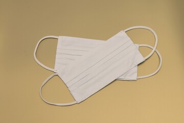 Two white fabric face masks designed to protect the wearer from spreading or acquiring a disease...
