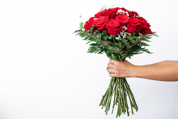 Hands holding bouquet of red roses on white background for gift. Gift for lovers and Valentine.
