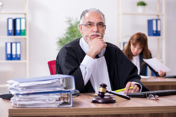 Old male judge and his young secretary in the office