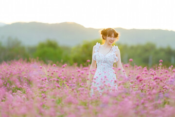 Fototapeta na wymiar Beautiful Asian woman wear white dress walking in pink flowers garden.