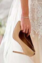 wedding dress and shoes on the hand bride