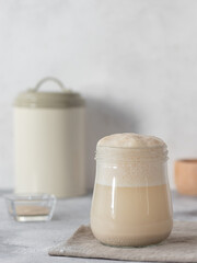 Active yeast fermentation in warm water. homemade baking. grayray background. vertical image. copy space