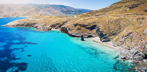 Panorama des Strandes Tis Grias to Pidima auf der Insel Andros, Kykladen, Griechenland, mit kristallklarem, türkisem Meer und karger Felslandschaft