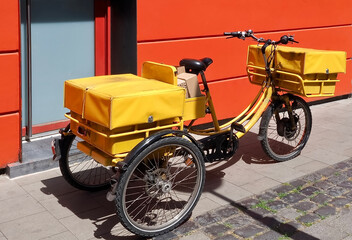 Fototapeta na wymiar Yellow bicycle of a post man or a post woman to carry out letters and parcels
